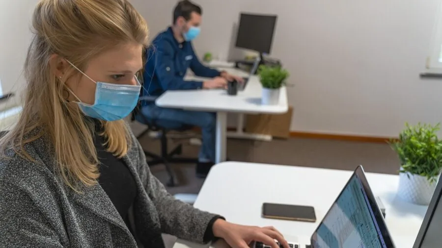 Parent watching baby monitor while working in another room of home
