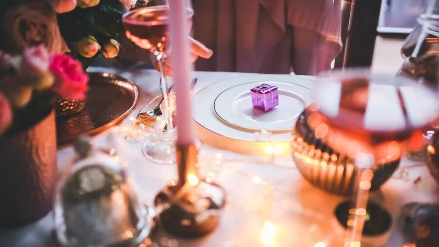 People dining closely together at wooden table, sharing meal in intimate setting
