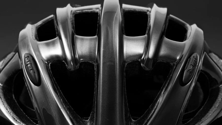 Person adjusting bike helmet fit system before riding, focusing on proper head retention and safety preparation