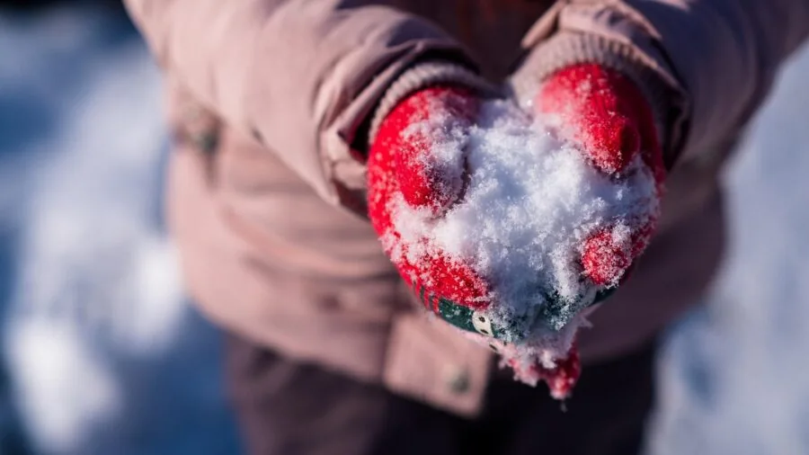 Person adjusting fitted winter gloves while getting ready for outdoor snow activities