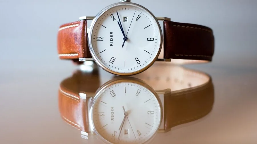 Person adjusting luxury watch strap, showcasing bracelet customization and style options