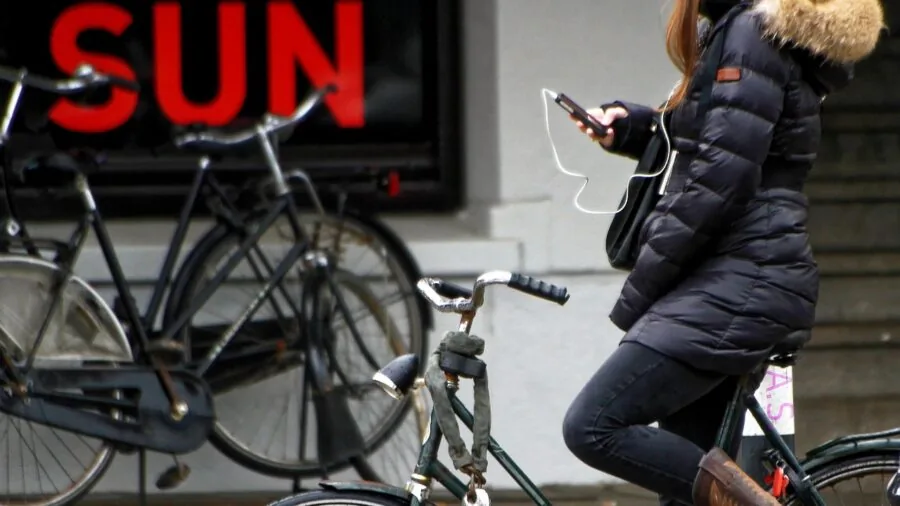 Person adjusting smartphone on tripod mount for video recording or content creation
