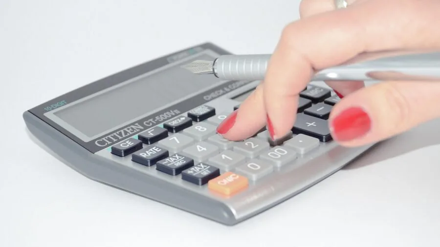 Person analyzing costs and comparing value options with calculator and documents on desk