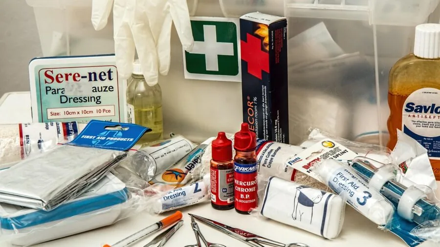 Person applying a bandage to a minor wound on their hand during first aid treatment
