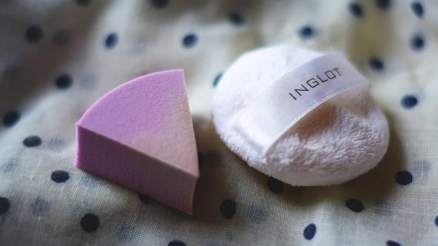 Person applying makeup with sponge using stippling technique on face