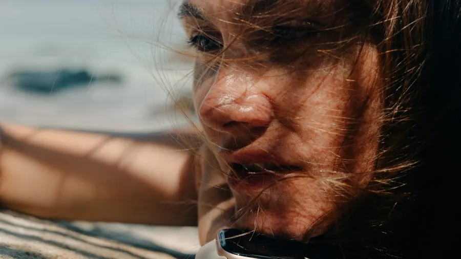 Person applying sunscreen to their face while sitting outside on a sunny day