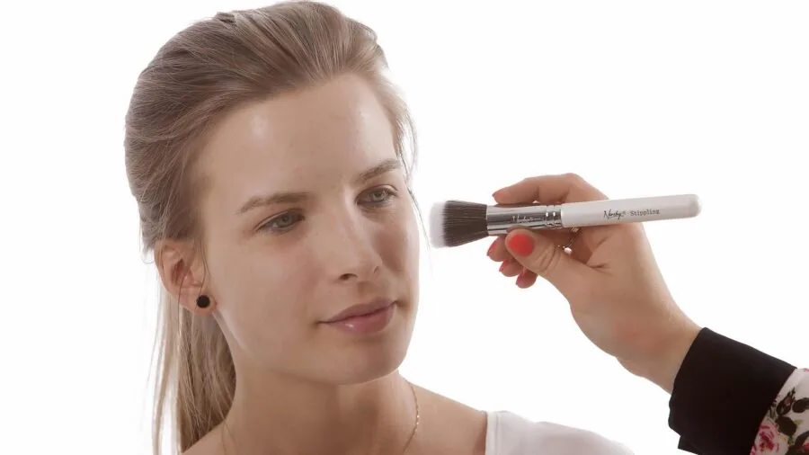Person applying toner with cotton round during morning skincare routine