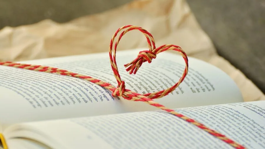 Person arranging a gift set of page holders with books and personal items on a table