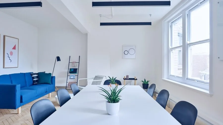 Person assembling a desk with basic tools in a bright home workspace environment