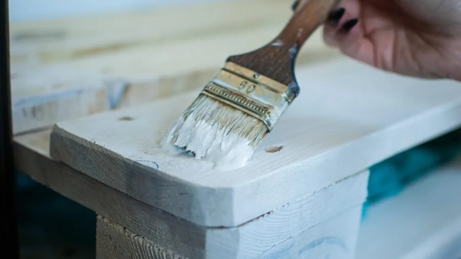 Person assembling bed frame with basic hand tools in bright bedroom