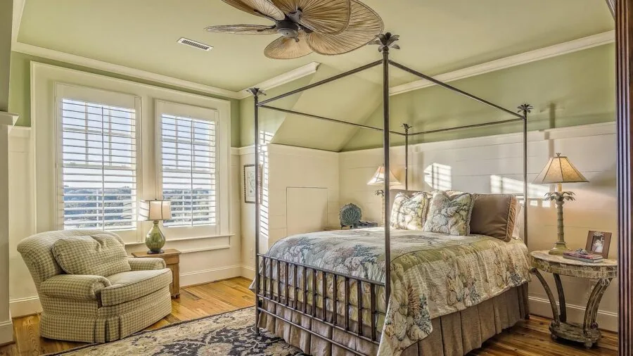 Person assembling bed frame with tools and instructions in modern bedroom setting