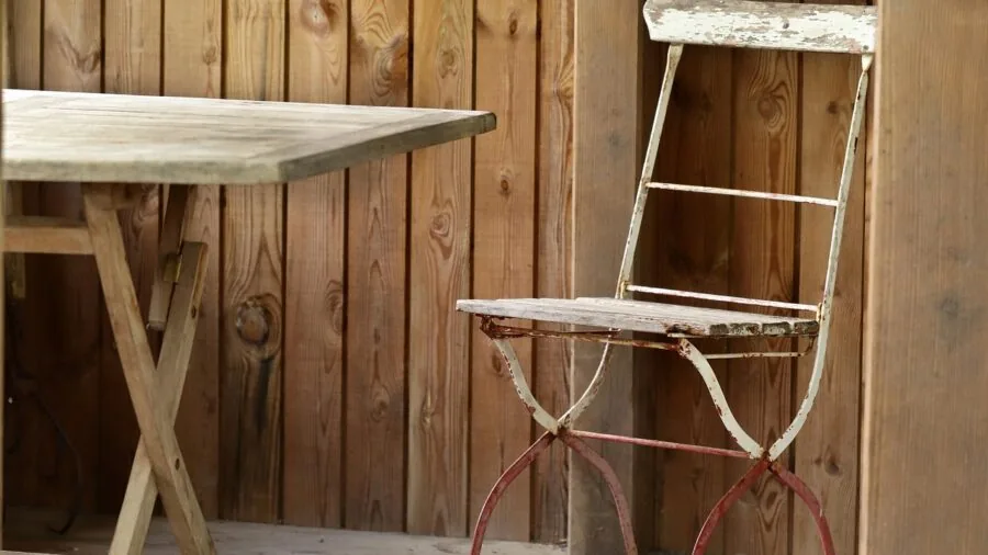 Person assembling dining chair legs to seat base during furniture setup at home