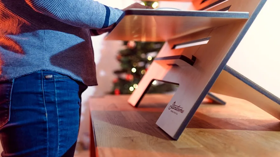 Person assembling wooden furniture at home with tools and instruction manual