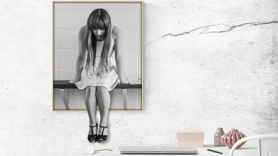 Person at desk dealing with office equipment frustration, representing common workplace challenges