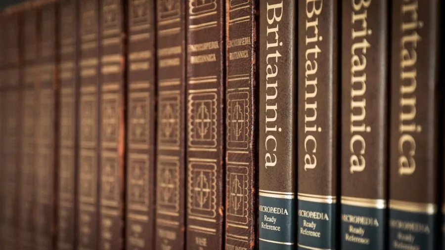 Person browsing books on wooden shelf, selecting reading material for collection