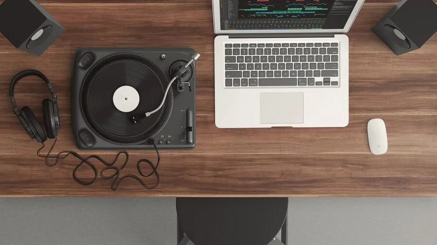 Person carefully adjusting audio equipment knobs and settings while wearing headphones in a home studio environment
