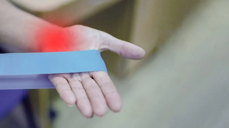 Person carefully adjusting intensity controls on a therapeutic device during home treatment