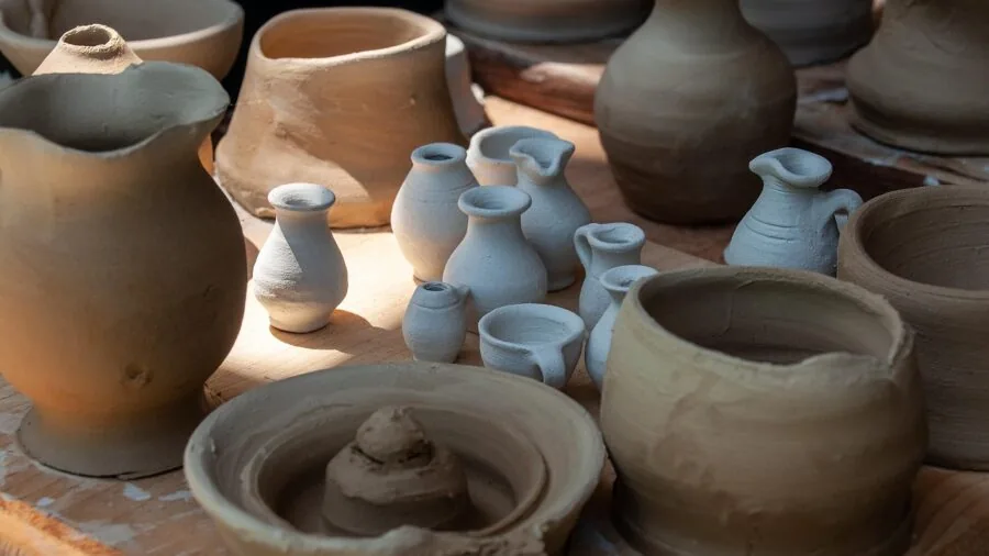 Person carefully bonding broken ceramic pieces together, demonstrating adhesive repair on non-porous surfaces