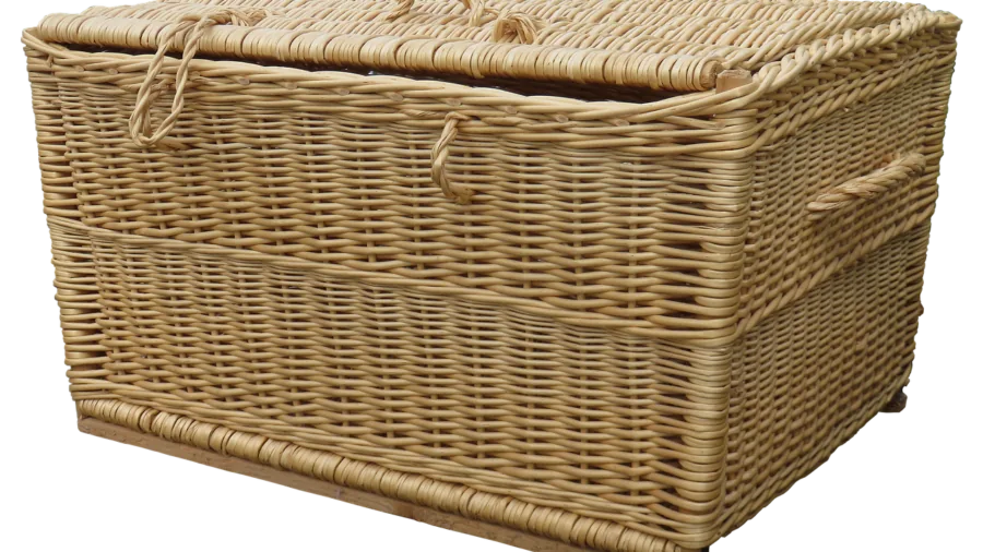 Person carefully carrying a full laundry hamper down wooden stairs in a home