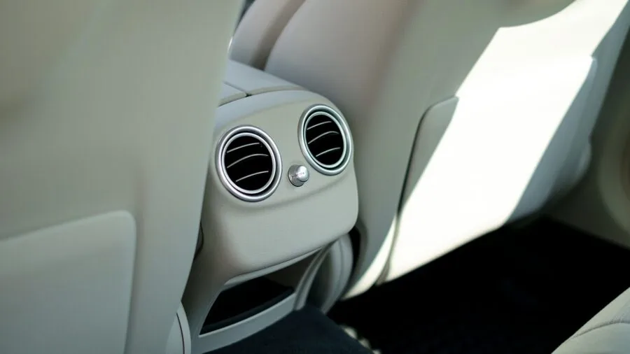 Person carefully cleaning car interior dashboard and trim with soft brush