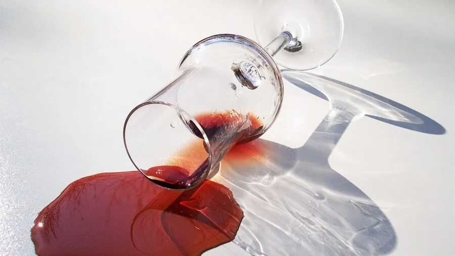 Person carefully cleaning inside of wine glass with brush, showing detailed household cleaning care