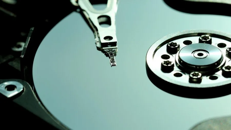 Person carefully examining a memory card with magnifying glass to verify authenticity and quality