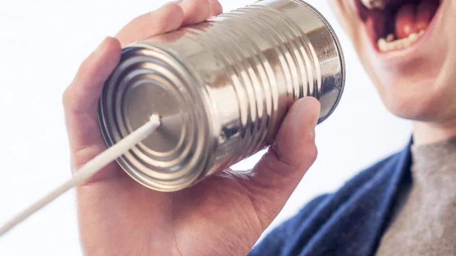 Person carefully handling an open can with sharp metal edges in a kitchen setting