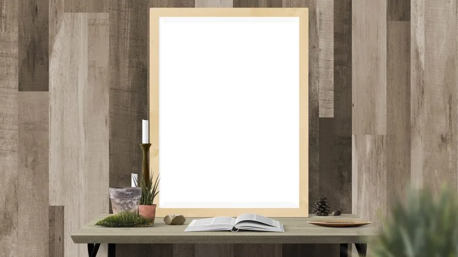 Person carefully hanging a framed artwork on a wall, demonstrating proper wall anchor installation techniques