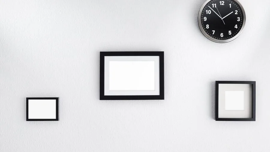 Person carefully hanging framed artwork on apartment wall