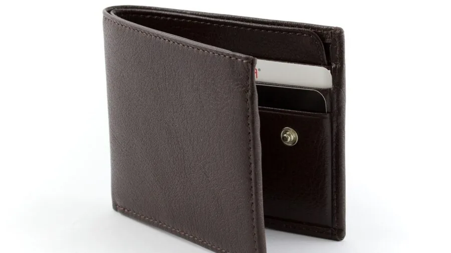 Person carefully holding wallet close to body, demonstrating financial security and protection awareness