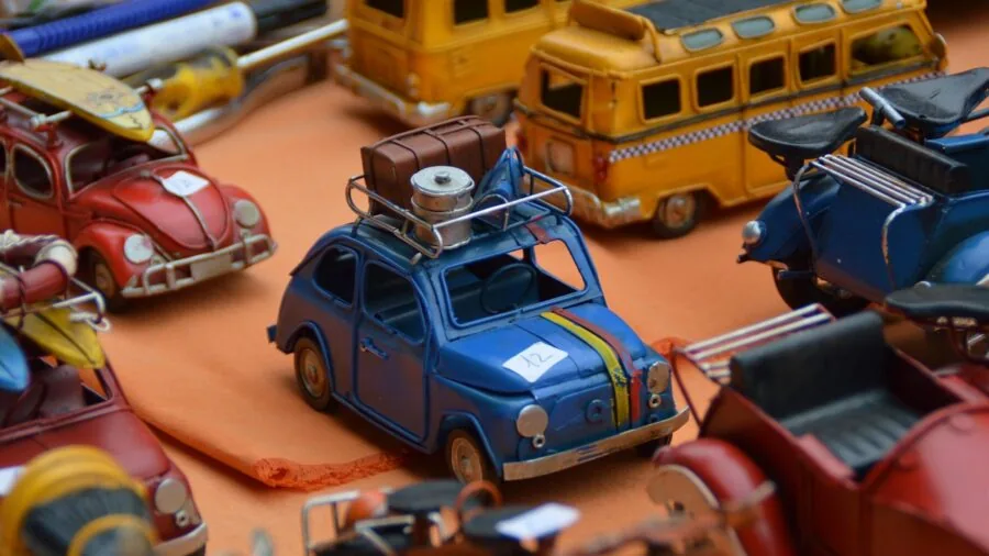 Person carefully inspecting a detailed miniature automobile model with focus on craftsmanship and accuracy