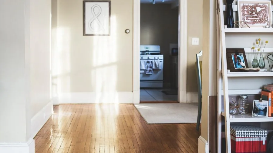 Person carefully maneuvering furniture through a narrow doorway in a home interior