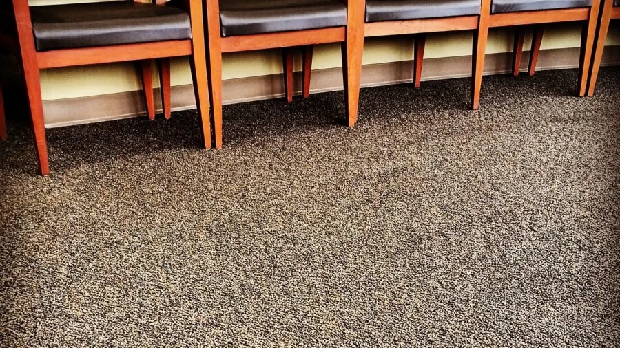 Person carefully moving wooden furniture with protective padding and blankets on floor
