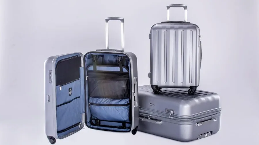 Person carefully organizing and folding clothes inside an open duffel bag for travel