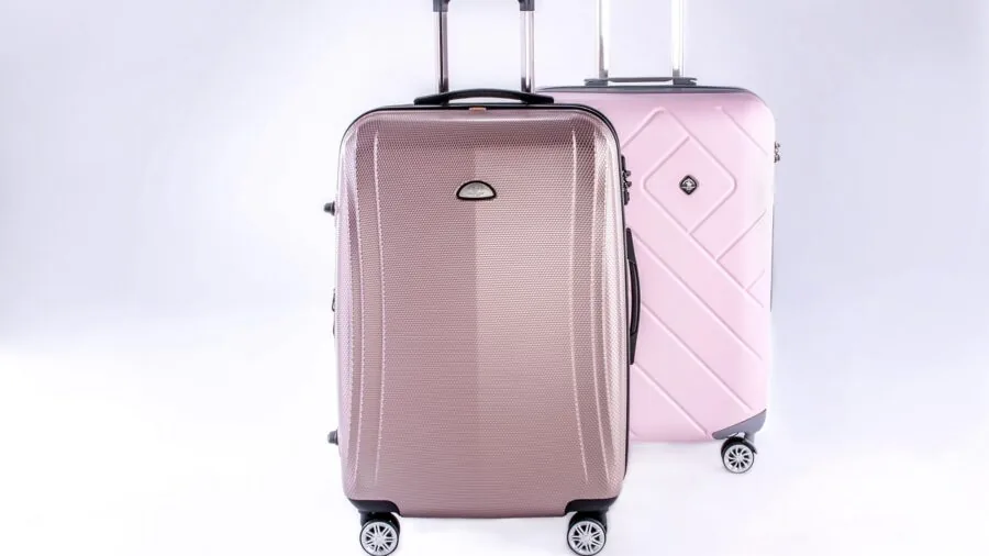 Person carefully packing soft luggage with protective padding in car trunk during family trip