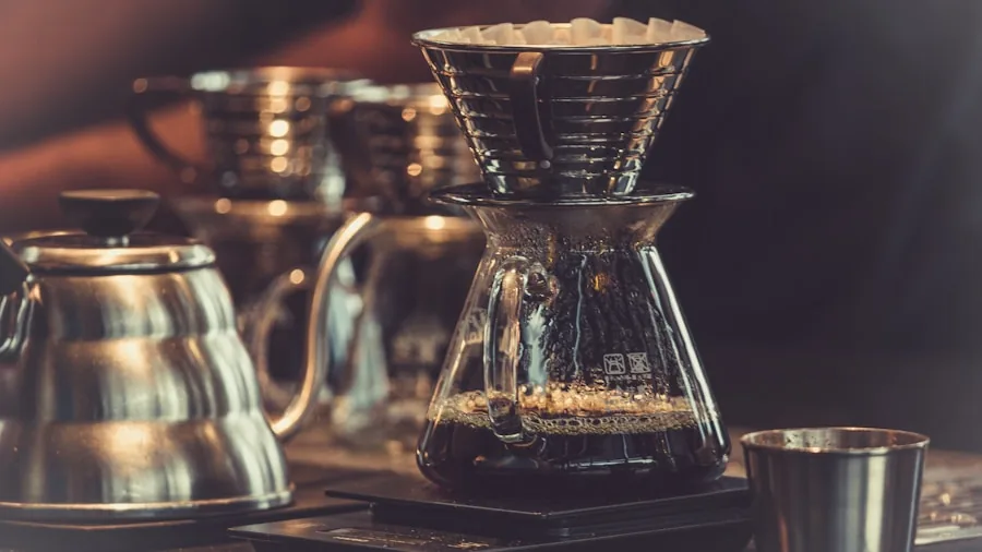Person carefully pouring hot water into coffee grounds with focused attention to brewing technique