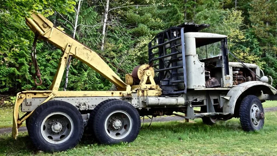 Person carefully securing wrapped furniture inside moving truck with straps and blankets