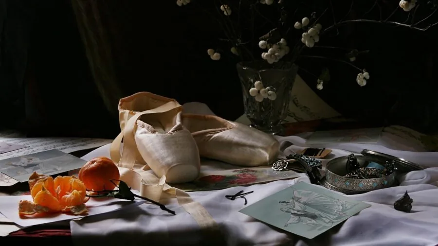 Person carefully sorting and organizing collectible stamps at a wooden desk with natural lighting