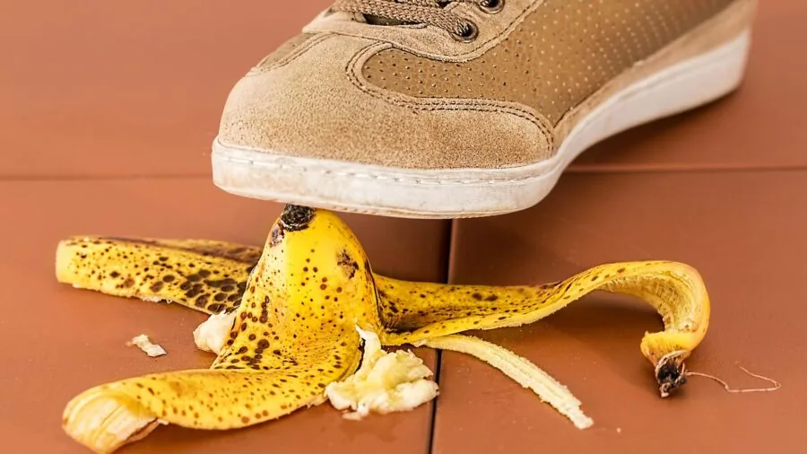 Person carefully stepping on wet bathroom floor near bathtub, demonstrating slip hazard awareness