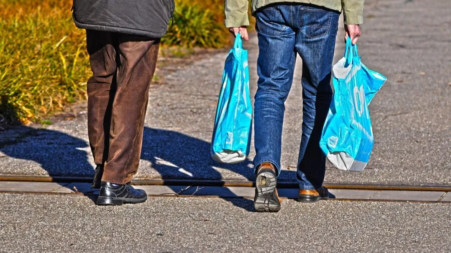 Person carrying portable organizer bag to outdoor tailgate event with friends and family
