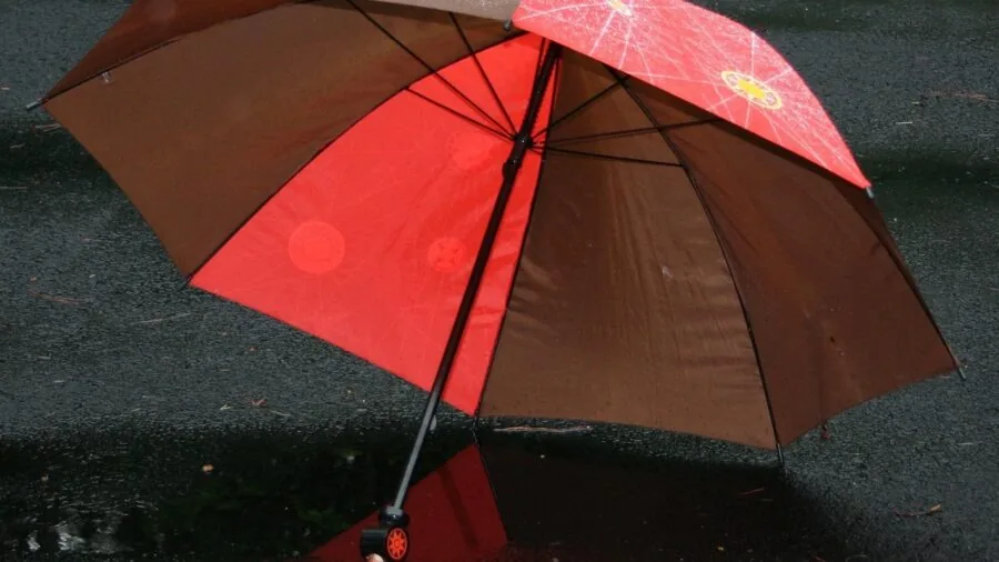 Person carrying weather-resistant bag in light rain, demonstrating practical outdoor durability