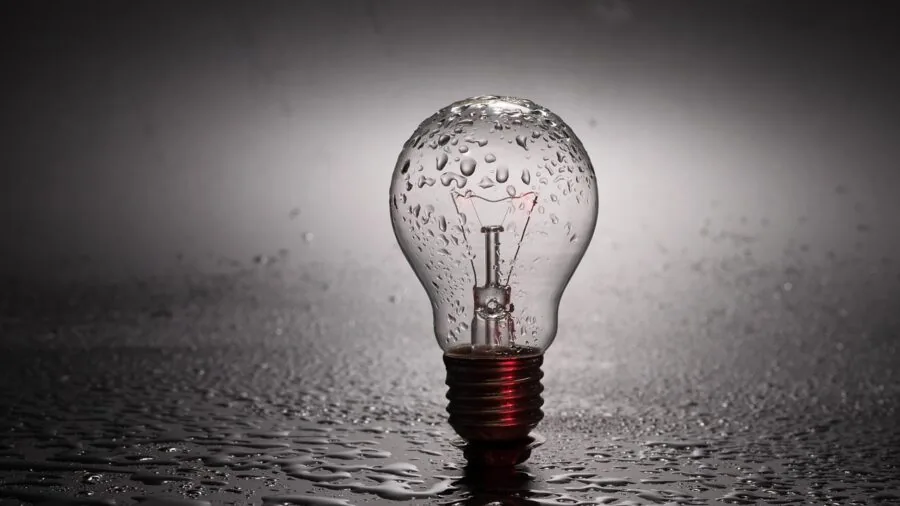 Person changing a light bulb in home fixture, representing LED bulb longevity and durability