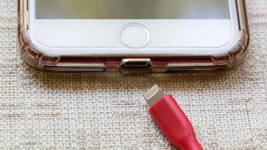 Person charging a portable device with USB cable during home DIY project setup