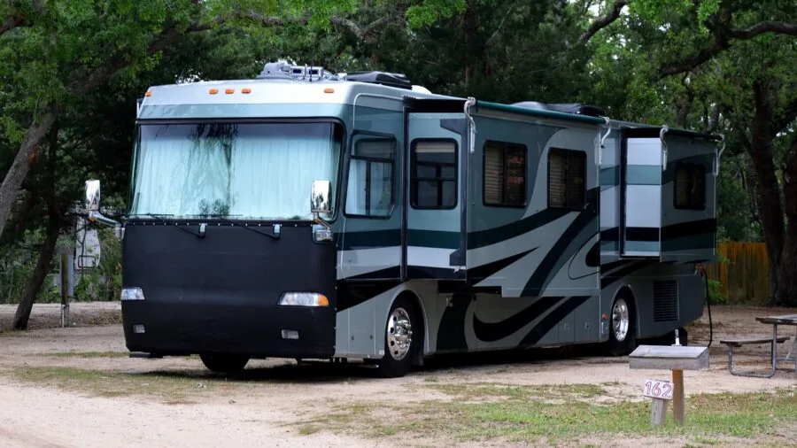Person charging devices at campsite near vehicle during outdoor adventure trip