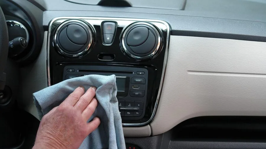 Person charging smartphone in vehicle using car charger cable while driving