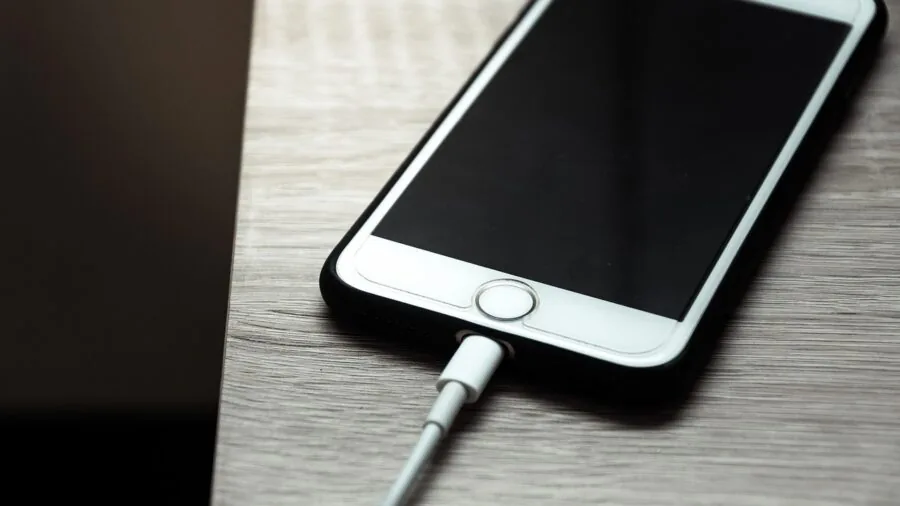 Person checking camera battery life while on outdoor adventure, preparing equipment for travel