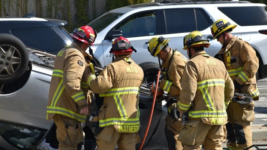 Person checking emergency safety kit in car trunk with fire extinguisher and first aid supplies