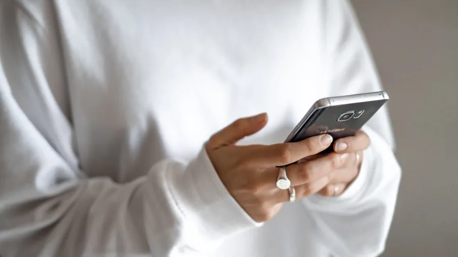 Person checking smartphone temperature while using wireless charging in everyday setting