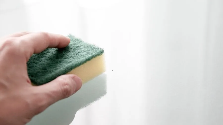 Person cleaning pet hair from hands and gloves after grooming session