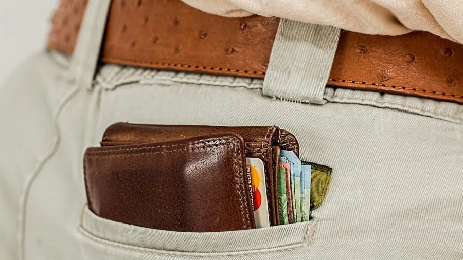 Person comparing different leather wallets and organizers on wooden table